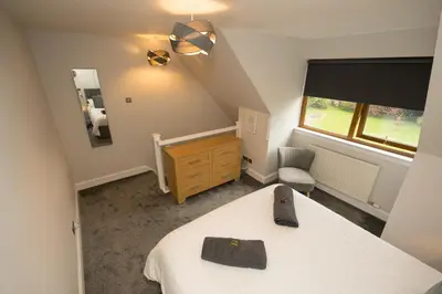 a bedroom with a bed and a dresser and a window at Tigh Na Cille Studio in Taynuilt