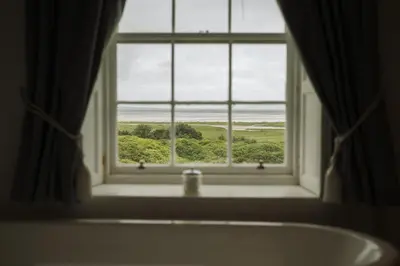 a window in a bathroom with a bath tub and a view at Islay House in Bridgend