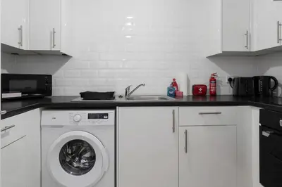 a kitchen with a washing machine and a sink at Free Parking - Sleeps 6 - Central - New Interior in Greenock