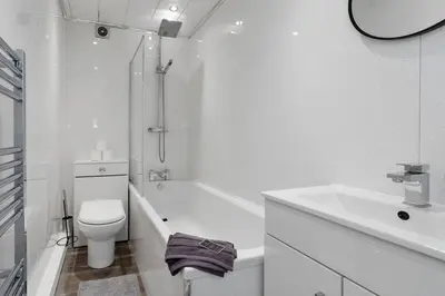 a white bathroom with a toilet and a sink at Free Parking - Sleeps 6 - Central - New Interior in Greenock