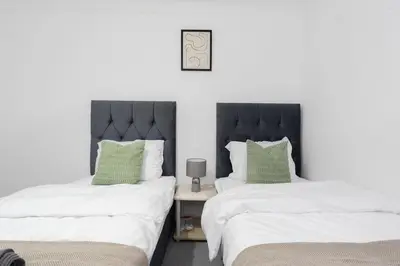 two beds sitting next to each other in a bedroom at Free Parking - Sleeps 6 - Central - New Interior in Greenock