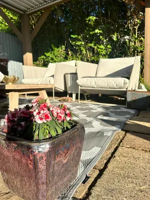 a planter with flowers in it on a patio at Peaceful and Stylish Garden Flat Close to Transport and City Centre in Glasgow