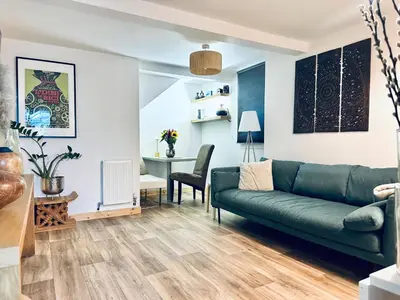 a living room with a green couch and a table at Peaceful and Stylish Garden Flat Close to Transport and City Centre in Glasgow