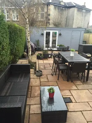 a patio with a table and chairs and a table and sidx sidx sidx at Peaceful and Stylish Garden Flat Close to Transport and City Centre in Glasgow
