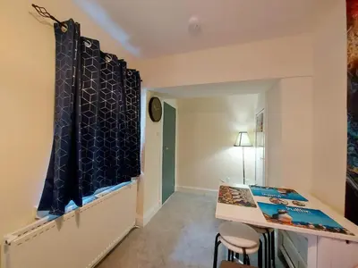 a room with a desk and a table with chairs at The Puffins - Largs 2-Bedroom Ground Flat in Largs