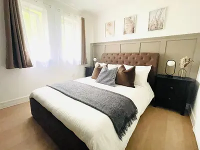 a bedroom with a large bed with pillows on it at Lovely 1-bedroom Apt in Glasgow City near Subway in Glasgow