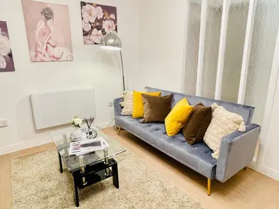 a living room with a blue couch with yellow pillows at Lovely 1-bedroom Apt in Glasgow City near Subway in Glasgow