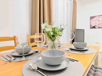 a dining room table with plates and wine glasses at Lovely 1-bedroom Apt in Glasgow City near Subway in Glasgow