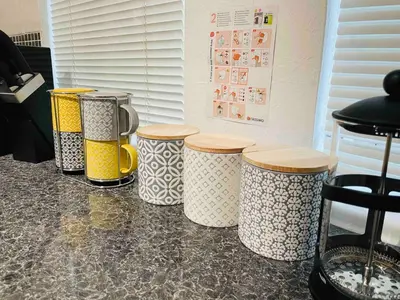 a row of five different colored containers on a counter at Lovely 1-bedroom Apt in Glasgow City near Subway in Glasgow