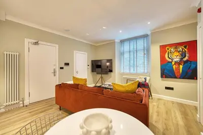a living room with a couch and a painting of a tiger at City Oasis Craigpark Residence in Glasgow