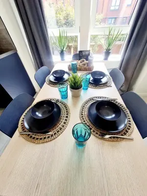 a table with plates and bowls on top at Modern Apartment - FREE parking in Glasgow