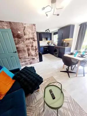 a living room with a blue couch and a table at Modern Apartment - FREE parking in Glasgow