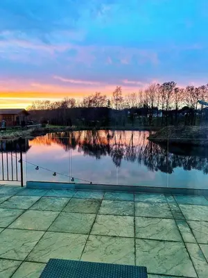 a view of a lake with a sunset in the background at Lakeside Lodge - Lakeside Lodge Retreat - Golf & Spa, Gleneagles in Dunning