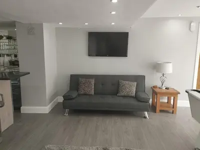a living room with a couch and a tv at 2 Bedroom Garden Flat in Bearsden