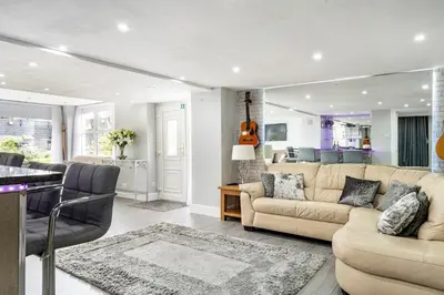 a living room with a couch and a table at 2 Bedroom Garden Flat in Bearsden