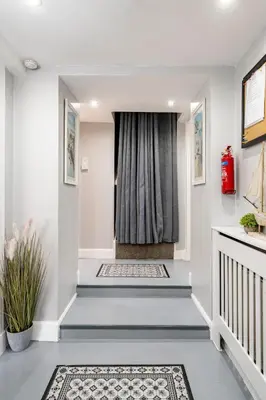 a hallway with stairs with a window and a rug at 2 Bedroom Garden Flat in Bearsden