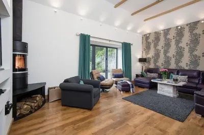 a living room with a couch and a fireplace at Arrochar House in Tarbet