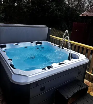 a bath tub with water coming out of it at Hunters Quay - Hot Tub Lodge at Limecroft 6 in Hunters Quay