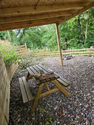 a picnic table and a bench under a pavilion at Lochview Apartment in Tarbet