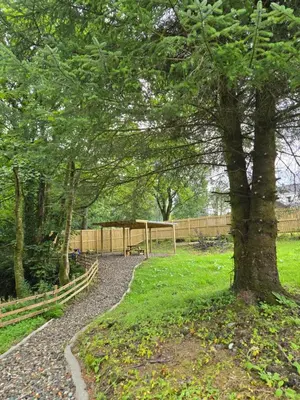 a park with a tree and a fence at Lochview Apartment in Tarbet