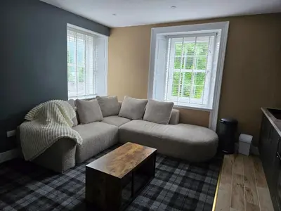 a living room with a couch and a coffee table at Lochview Apartment in Tarbet