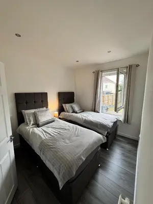 a bedroom with two beds and a window at Modern and stylish 3 bedroom 2 bathroom west end house with Free WiFi and parking in Scotstoun West Station