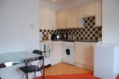a kitchen with a washing machine and a washer at Grassmarket-Old Town Apartment in Edinburgh