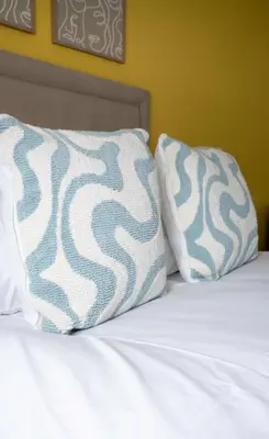 a bed with two pillows on top of it at 3 BDR House By Caledonia Luxe Stays Short Lets & Serviced Accommodation Broxburn in Broxburn