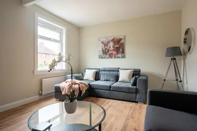 a living room with a couch and a glass table at Pinkerton House in Dunfermline