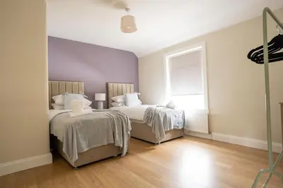 a bedroom with two beds and a window at Pinkerton House in Dunfermline