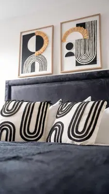 a bedroom with a bed with two pictures on the wall at Torbrex House in Cumbernauld