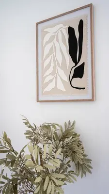 a picture hanging on a wall with a plant at Torbrex House in Cumbernauld