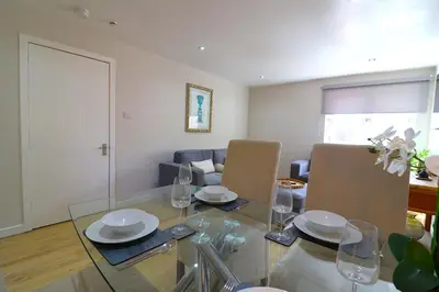 a living room with a glass table and chairs at Signature - Wellhead View in Lanark