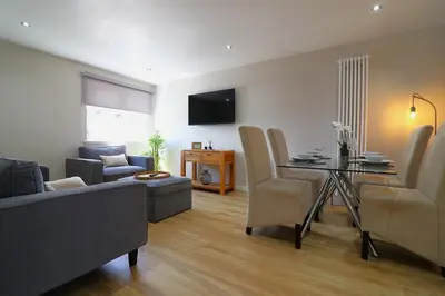 a living room with a couch and a dining room at Signature - Wellhead View in Lanark