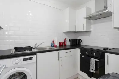 a kitchen with a washing machine and a sink at Free Parking - Sleeps 6 - 2 Bedrooms - Newly Renovated in Greenock
