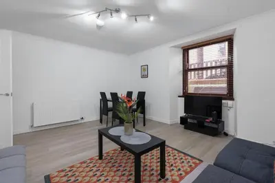 a living room with a couch and a table at Free Parking - Sleeps 6 - 2 Bedrooms - Newly Renovated in Greenock