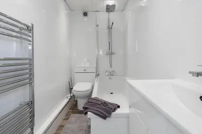 a white bathroom with a toilet and a bath tub at Free Parking - Sleeps 6 - 2 Bedrooms - Newly Renovated in Greenock