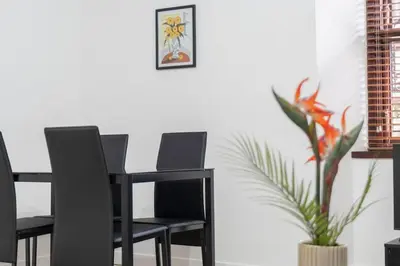 a black dining room table with two chairs and a plant at Free Parking - Sleeps 6 - 2 Bedrooms - Newly Renovated in Greenock
