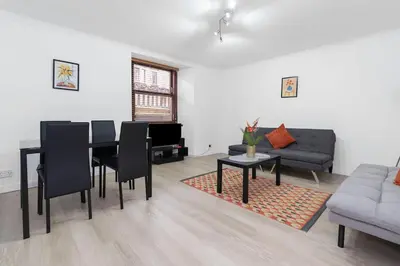 a living room with a table and a couch at Free Parking - Sleeps 6 - 2 Bedrooms - Newly Renovated in Greenock