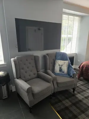a couch and a chair in a living room at Ben Lomond Apartment in Tarbet