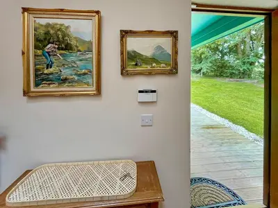 a door into a room with paintings on the wall at Foxglove Cottage 1 - Uk50019 in Drymen