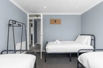a room with two beds and a mirror at Free Parking - Central - Sleeps 8 - 3 Bedrooms in Livingston