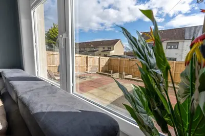 a living room with a large window and a couch at Free Parking - Central - Sleeps 8 - 3 Bedrooms in Livingston