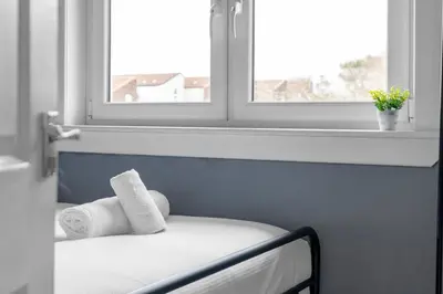 a bed with two towels on it next to a window at Free Parking - Central - Sleeps 8 - 3 Bedrooms in Livingston