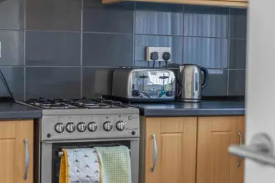 a kitchen with a stove and a microwave at Free Parking - Central - Sleeps 6 - 2 Bedrooms in Livingston