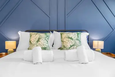 a bed with white sheets and pillows in a room at Free Parking - Central - Sleeps 6 - 2 Bedrooms in Livingston