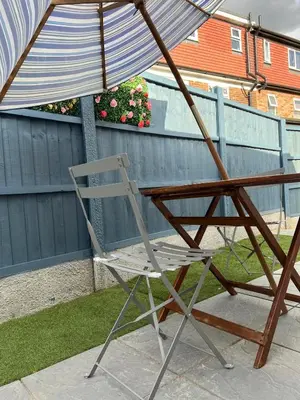 a chair sitting under an umbrella on a patio at Love Shack - Cozy 1BR Walthamstow in Moffat