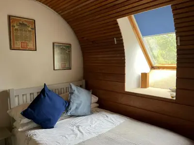 a bed with blue pillows in a room with a window at Edinburgh whole house let for DP World Tour, overlooking Bruntsfield Links 18th fairway, 30 min drive from The Renaissance Club in Edinburgh