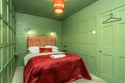 a bedroom with a bed with a red blanket at New Town Cottage in Edinburgh