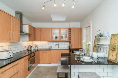 a kitchen with wooden cabinets and a black counter top at New Town Cottage in Edinburgh